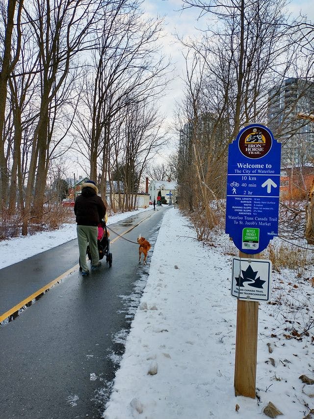 A father walking his daughter and dog down the Iron Horse trail near Uptown Waterloo